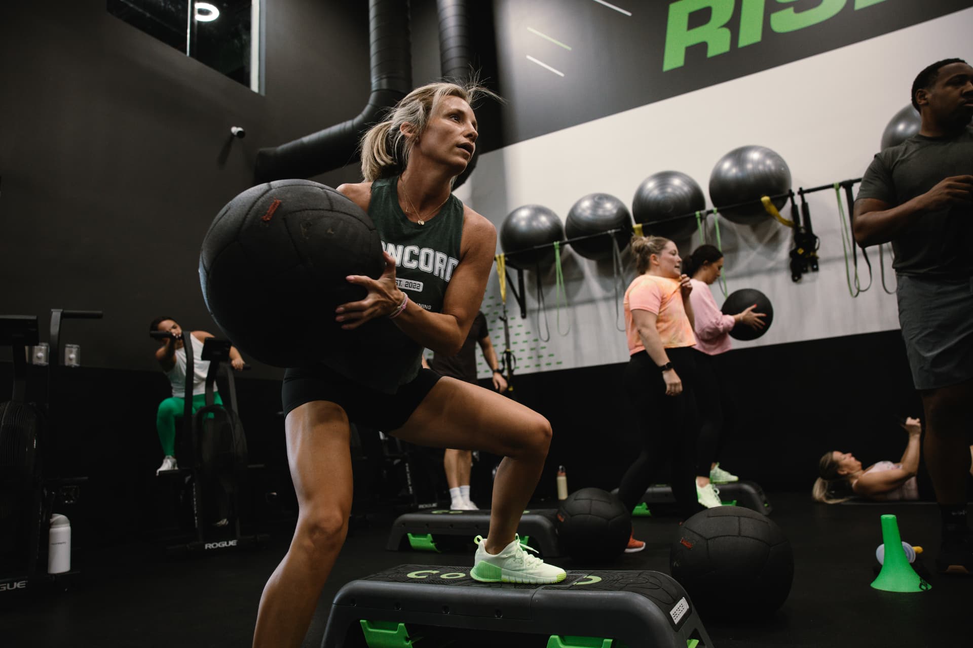 An ISI Elite Training athlete front-squatting a medicine ball during a coach-led class